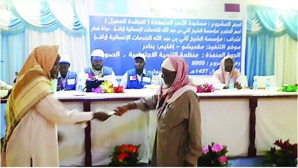 A Somali citizen receiving money from a RAF representative in a ceremony in capital Mogadishu.