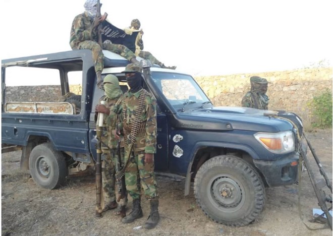 Al-Shabaab militants posing next to a captured Kenya police land-cruiser from Hamey police post.