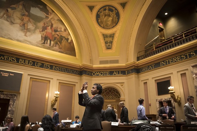Dressed in a suit and tie, Mohamed Hassan took a picture of the Minnesota State Capitol Senate Chambers as he participated in a Youth in Government model assembly session on January 6, 2017, in St. Paul, Minn. Renee Jones Schneider