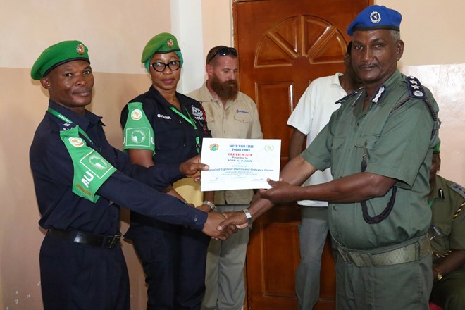 Tresphord Kasale, the AMISOM Police Coordinator for South West state, presents a certificate to one of the trainees during a training course on Improvised Explosive Devices (IED) & Explosive Ordinance Devices (EOD) for Southwest police forces, conducted by the African Union Mission in Somalia (AMISOM) in Baidoa, Somalia, on December 16, 2017. AMISOM Photo