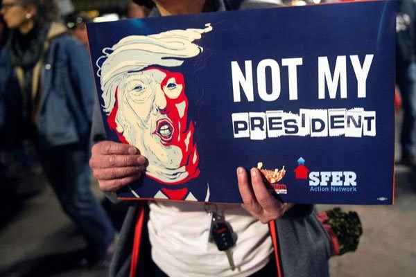 A demonstrator holds an anti-Trump sign during a President's Day protest march in Denver, Colorado on February 20, 2017. PHOTO | JASON CONNOLLY | AFP