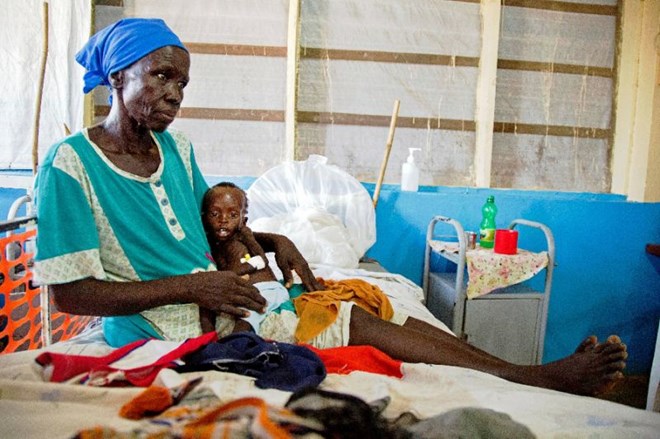 Regina Aluel holds her grandson Agop Manut, 11-months-old, who suffers acute malnutrition and respiratory distress at the clinic run by Doctors Without Borders in Aweil, northern Bahr al-Ghazal, South Sudan in 2016 (AFP Photo/ALBERT GONZALEZ FARRAN)