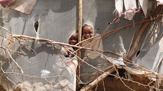 Two girls peer into the compound of Abdulaziz Yassir Yahya, their Sudanese neighbor who was scheduled to fly from Kakuma refugee camp to Nairobi on January 30, for processing for his resettlement in Tucson, Arizona. The U.S. travel ban prevented him from doing so. He now waits for more information in Kakuma, Kenya, Feb. 6, 2017. (J. Craig / VOA)