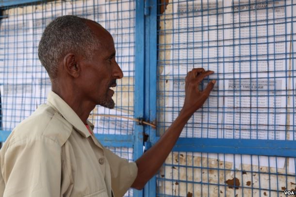 Somali man in Kakuma refugee camp checks the board to see if his name is on the list for an interview with the International Organization for Migration (IOM) for potential resettlement to the U.S. in Kakuma, Kenya, Feb. 6, 2017. (J. Craig / VOA)