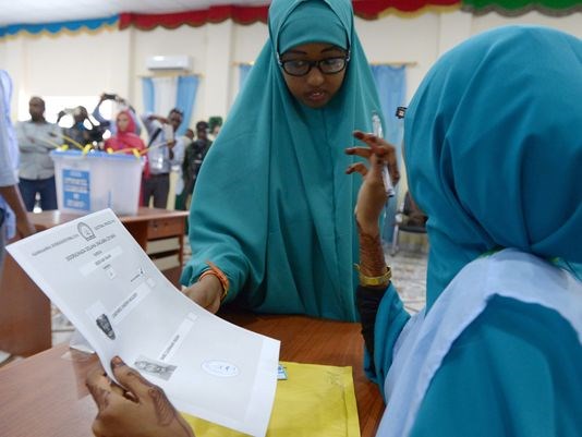 This photo taken on Nov. 16, 2016, shows a Somali poll worker, right, explaining the voting procedure to a voter before she casts her ballot in Baidoa.