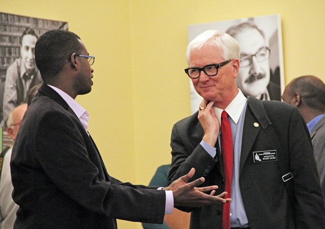 Sandol Khalaf of Shanta Link, a Somali-run scholarship program based in St. Paul, strikes up a conversation with Rep. Duane Sauke, DFL-Rochester, at a Capitol sambusa event on Jan. 23, 2017. Laura Yuen | MPR News