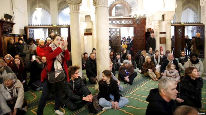 Visitors watch members of the Muslim community praying in the Paris Grand Mosque during an open day weekend for mosques in France, Jan. 10, 2016.