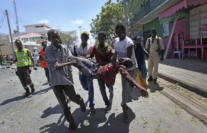 Rescuers carry away a man who was wounded in a car bomb attack in Mogadishu, Somalia Monday, March 13, 2017. A suicide car bomber detonated near the Weheliye hotel in the capital Monday morning, killing a number of people on the busy Maka Almukarramah road, police said. (AP Photo/Farah Abdi Warsameh)