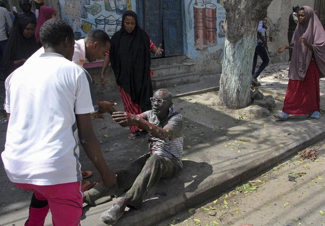 A wounded man reaches out to rescuers after a car bomb attack in Mogadishu, Somalia Monday, March 13, 2017. A suicide car bomber detonated near the Weheliye hotel in the capital Monday morning, killing a number of people on the busy Maka Almukarramah road, police said. (AP Photo/Farah Abdi Warsameh)