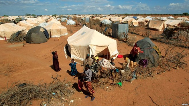 FILE - Refugees stand outside their tent at the Dadaab camp near the Kenya-Somalia border, Oct. 19, 2011. The Dadaab camp has hosted hundreds of thousands of Somali refugees for decades.