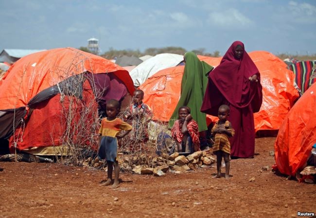 An internally displaced Somali family is seen outside their makeshift shelter at a camp after fleeing from drought stricken regions in Baidoa, west of Somalia's capital Mogadishu, April 9, 2017.