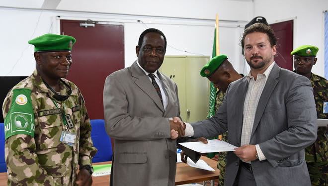 Ambassador Francisco Madeira, the Special Representative of the Chairperson of the African Union Commission (SRCC) for Somalia, presents a certificate to a participant during the closing session of a two-day seminar on Countering Improvised Explosive Devices (CIEDs) in Mogadishu, Somalia on 17 April 2018. AMISOM Photo / Omar Abdisalan