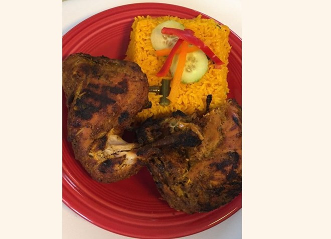 A half chicken from Maty’s African Restaurant in Detroit, served with yellow rice.