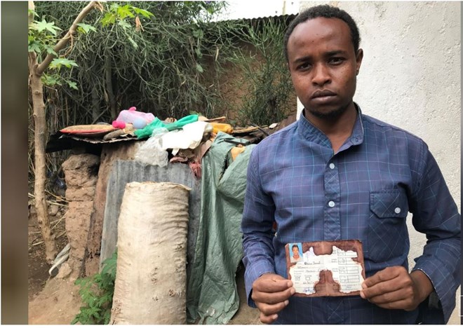 Abedir Jamal holds the identification card of his late brother Obsa Jemal, who was killed in anti-government protests, during a Reuters interview in Harar, Ethiopia July 22, 2018. REUTERS/Maggie Fick