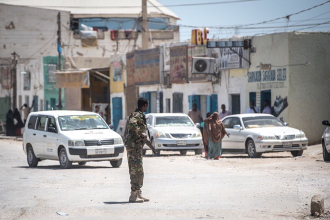 A Puntland police soldier directs traffic outside police headquarters in the economic hub city of Bossaso, Somalia, March 24, 2018. (J. Patinkin/VOA)