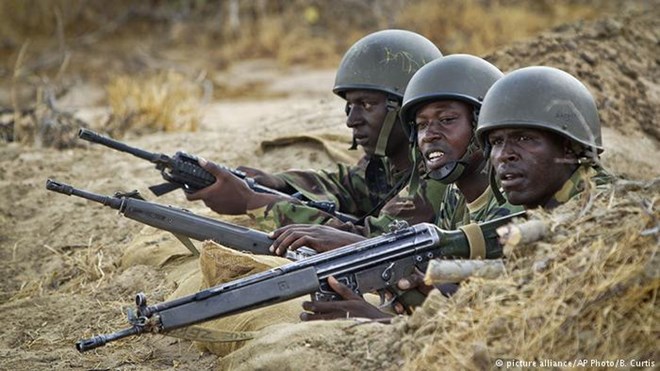 Kenyan army soldiers stand in a dugout position at their base in Tabda, inside Somalia