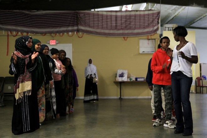 The boys and girls form separate lines at one point in the dance. When Salma got her first student identification card at Foster High School, she showed her friends and compared their cards to her mom’s, Esther, who also went to Foster High School. “Kids okay, they speak Somali, they know my language,” Esther said. “I don’t speak very well, I worry about me.” Esther got her GED but she had to put her education on hold multiple times because of her pregnancies. (Photo by Ester Ouli Kim.)