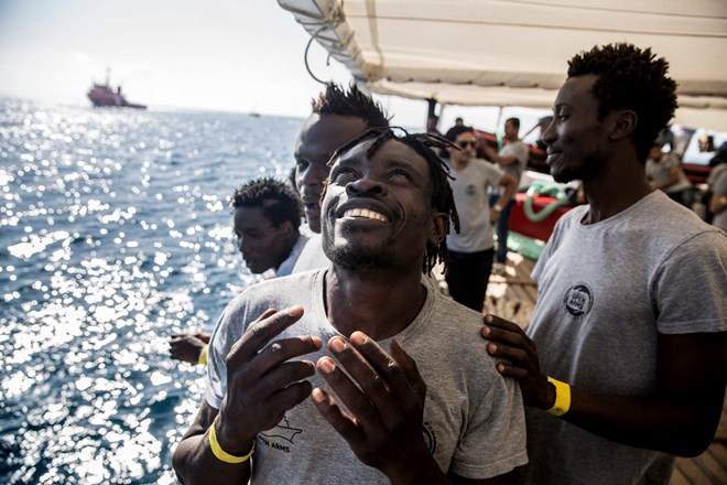 Joel, left, Honoré, and Gislain, right, reacting as the Open Arms aid boat approached the port of Barcelona. July 2018.CreditOlmo Calvo