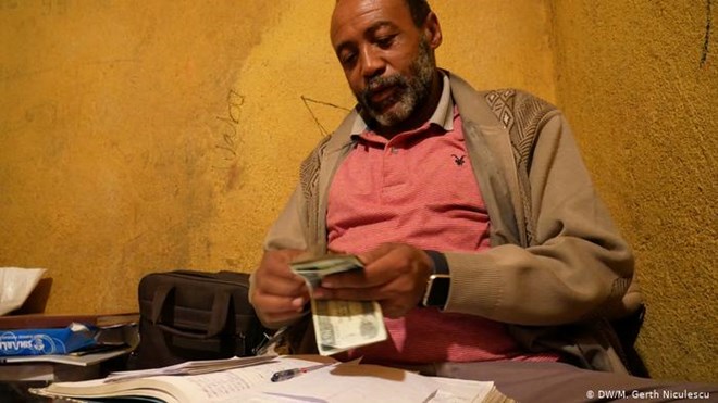 Trader Jarra Teklay Yohannes counts the day's income