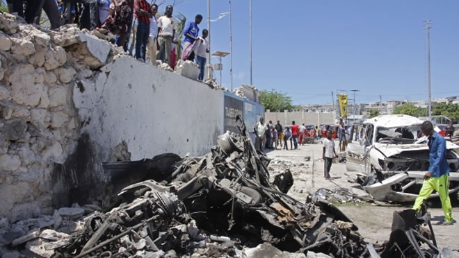 Somalis look at the wreckage after a suicide car bomb attack in the capital Mogadishu, Somalia, on May 22, 2019. (Farah Abdi Warsameh / AP)